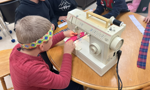 Group of students using a sewing machine